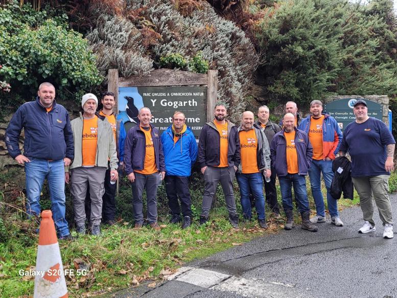 Tweleve Ground Control team members about to start their hike, posing in front of a national park sign