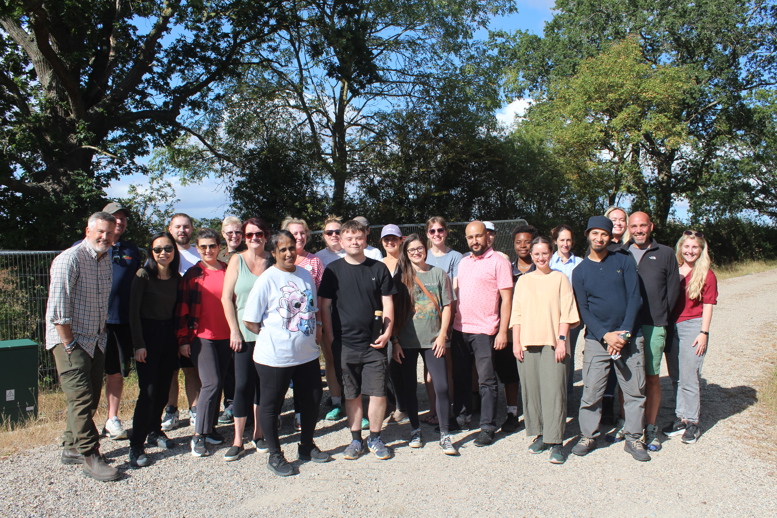 Group Tesco and Ground Controll emploees standing outdoors on a gravel path with trees in the background.