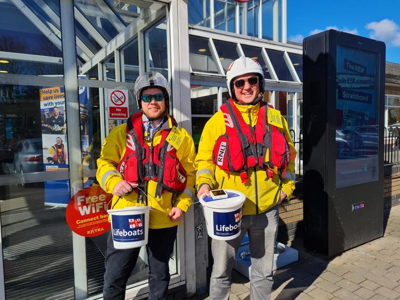 Fundraisers holding charity donation buckets, dressed in lifejackets
